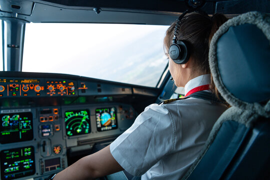 Female pilot flying commercial airplane during cruise flight phase