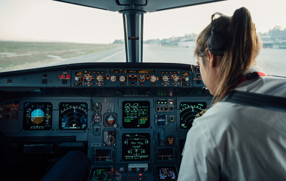 Female co-pilot inside airplane cockpit during pre-flight procedures