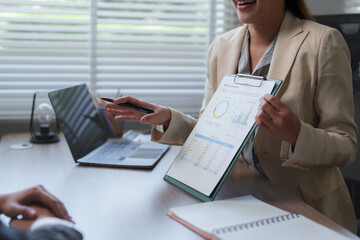 Businesswoman showing monthly budget report to her colleague during meeting