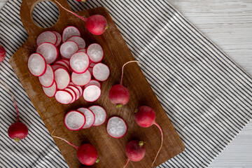 Raw Red Radish Slices on a Cutting Board, top view. Space for text.