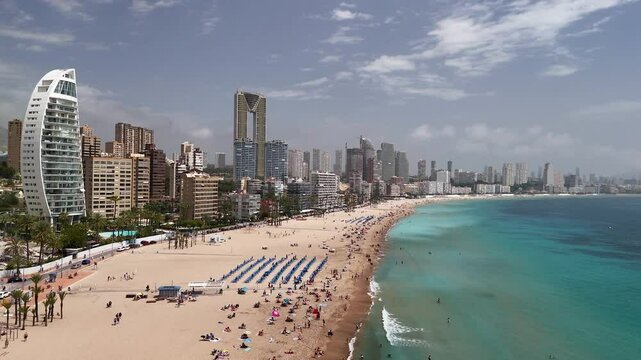 Benidorm beach, a renowned holiday hub, seen from an aerial perspective unveiling its dramatic coastal skyline and striking architectural giants. Alicante province, Spain.