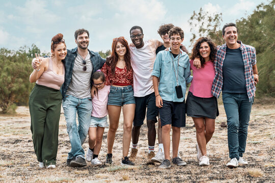 Diverse group of friends walking together outdoors in nature - multicultural different people bonding