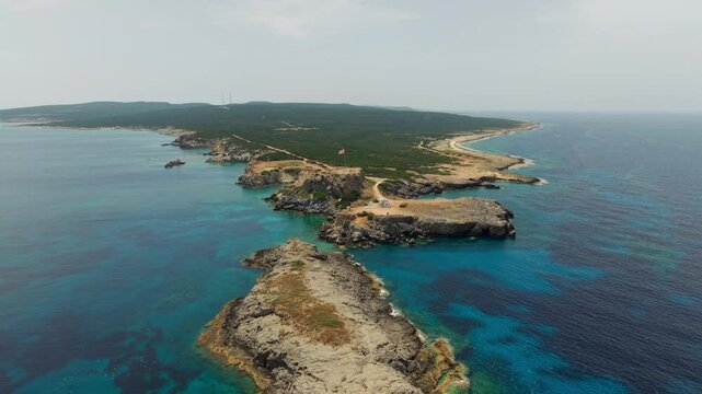Drone footage of Zafer Burnu showing Turkish and TRNC flags waving over a dramatic coastal cliff in Northern Cyprus under clear Mediterranean skies.