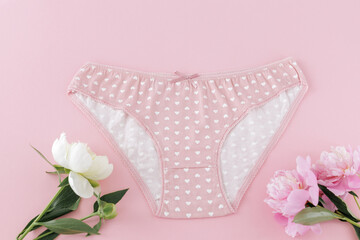 Pink cotton women's panties on the pink background.
