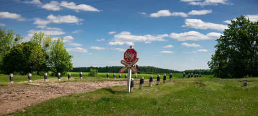 A stop sign at a railway crossing.Picturesque landscape along the railway.