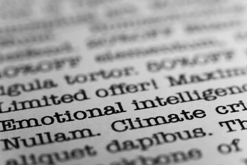 Emotional intelligence. Text printed on a page. A piece of paper with a phrase written in retro...