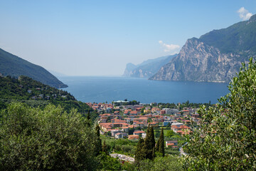 Panoramic view of Lake Garda (Trentino, Italy). View from Torbole of the mountain massif on the western shore. Sunny day, blue sky. Aerial photo