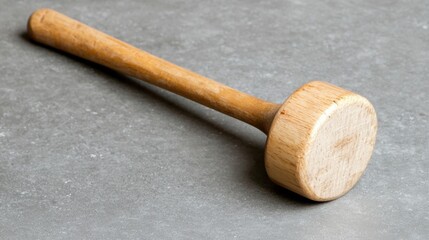 Wooden mallet on a gray surface.