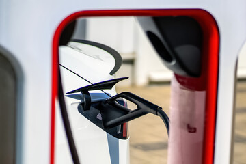 Detail of a connected charging station for a electric car. Charging an electric car at an outdoor charging station.