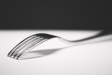 fork on white table with black background
