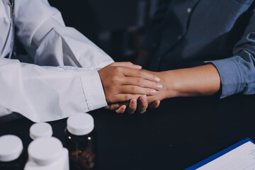 Fototapeta premium female doctor or woman medical staff holding hand, working hand in hand, giving encouragement to patient or relative of patient; concept of woman health care worker, doctor, therapist, medical worker