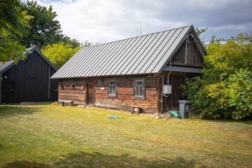A small house with a green trash can in front of it