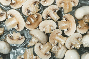 Raw White Mushrooms Champignons Close-Up Splash in a Water Top View