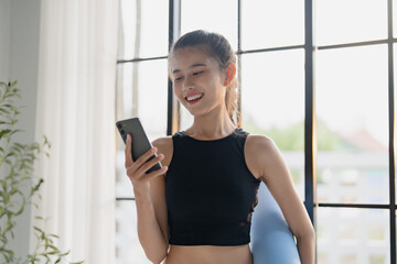 happy woman training at gym holding smartphone