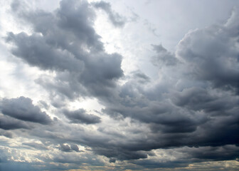 Obraz premium The sky is cloudy and grey, with a few dark clouds looming overhead. Scene is somber and foreboding, as if a storm is on the horizon. A photo of a sky filled with a dense array of dark.