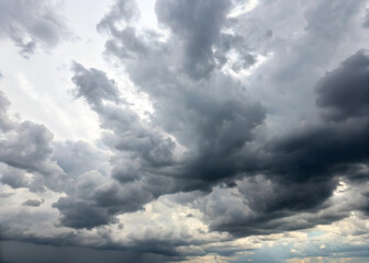 Obraz premium The sky is cloudy and grey, with a few dark clouds looming overhead. Scene is somber and foreboding, as if a storm is on the horizon. A photo of a sky filled with a dense array of dark.