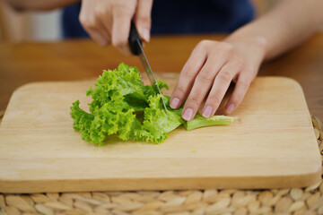 Happy young asian woman standing in kitchen and cooking healthy food. cook vegetable salad. Vegan Dieting Concept