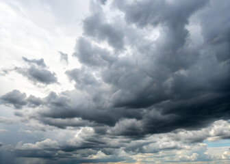 Obraz premium The sky is cloudy and grey, with a few dark clouds looming overhead. Scene is somber and foreboding, as if a storm is on the horizon. A photo of a sky filled with a dense array of dark.