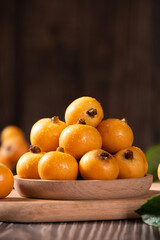 Ripe loquats fruit on wooden table.