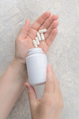 Mock-up of a tube for medicines or vitamins with the lid open. In a woman's hand. Product packaging mockup. Empty tube with space for logo and text.