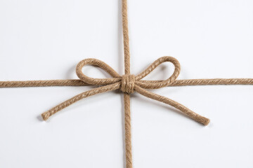 brown ribbon tied in a bow on a white background