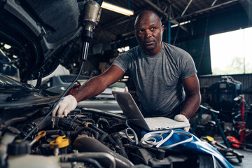 Auto mechanic are checking and repair maintenance auto engine is problems at car repair shop.
