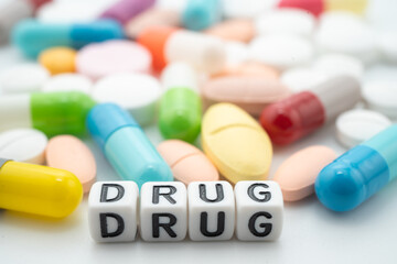 Drug word with pills and capsules medical drug.