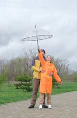 happy couple walking in the park in rainy day