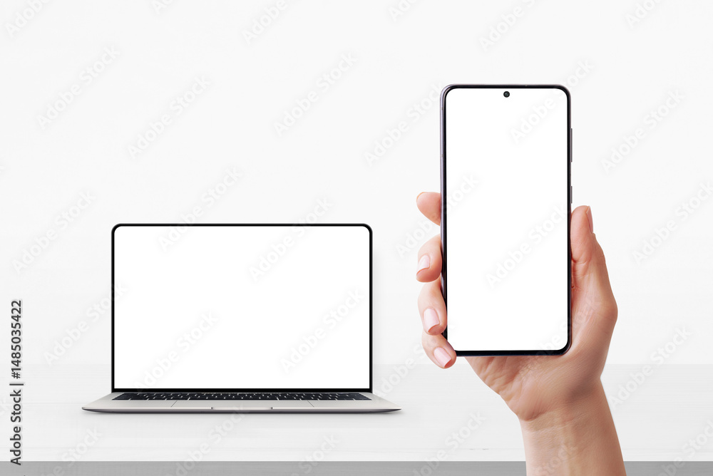 Poster Smartphone in hand with blank screen and laptop in background on desk, both ready for UI or branding mockup