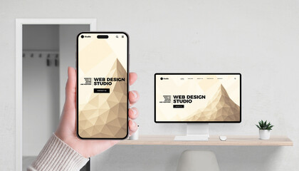 Web design studio concept with app and website shown on smartphone and computer in office setting