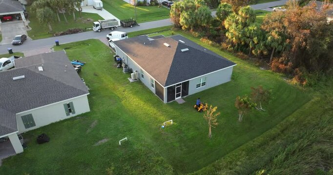 Lawn care service. Worker cutting grass with zero turn lawn mover tractor.