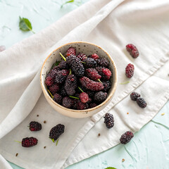 Fresh ripe berries in a bowl on a wooden table for a healthy and delicious treat