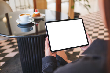 Mockup image of a woman holding digital tablet with blank white desktop screen in cafe
