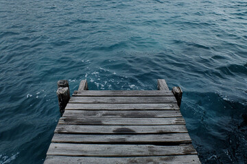 Fototapeta premium Wooden bridge connecting two shores symbolizing relationships and unity over calm waters