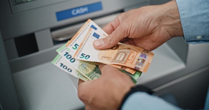Close Up of Unrecognizable Man, Businessman Counting Euro Bills in Hands After Withdrawing Cash Money Transaction from ATM Machine. Banking Services, Cash Withdrawal Systems, Financial Operations.