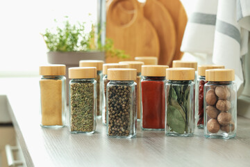 Many different aromatic spices in jars on countertop indoors