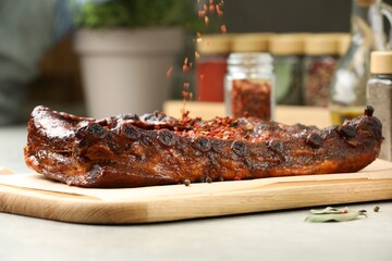 Adding spices to tasty dish at table, closeup