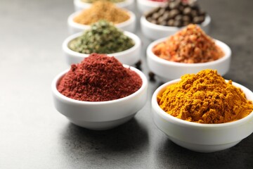 Different aromatic spices on grey table, closeup