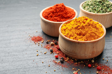 Different aromatic spices on black table, closeup. Space for text