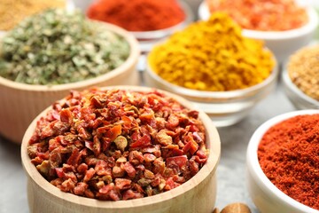 Different aromatic spices in bowls on table, closeup