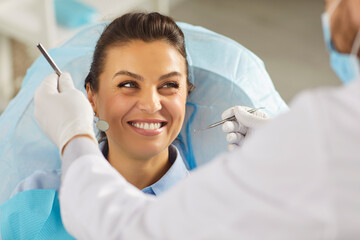 Dentist doctor or nurse examining a patient oral cavity using a dental tool in a clinic. Dental...