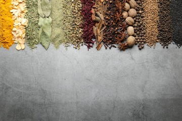 Many different spices on grey table, flat lay. Space for text