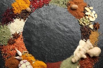 Different aromatic spices on dark textured table, top view. Space for text