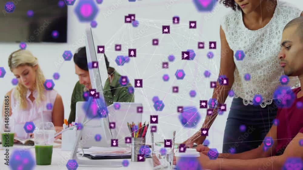 Aufkleber technology team collaborating around desk in office, showing floating network icons on monitor