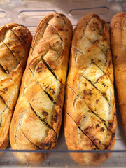 French baguette with garlic and herbs on a shelf in a supermarket