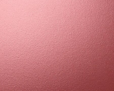 Abstract monochrome background with a glossy rough surface made of pink-gold foil and pink aluminum metal.