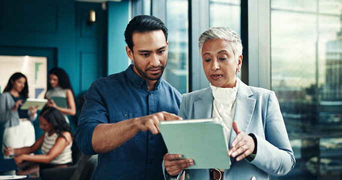 Collaboration, review and people with tablet, office and pointing of info on website, online and serious. Business, man and woman with feedback for project, teamwork and discussion for ad campaign - Powered by Adobe