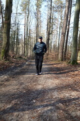 Obraz premium Man running on a trail in the forest on a sunny day