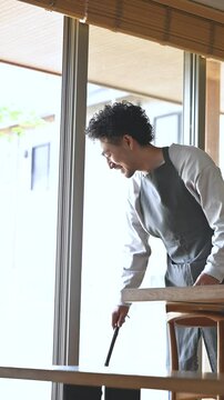 掃除を箒でする丁寧な暮らしの男性　田舎や地方移住などリタイアやfire後のライフスタイル縦動画