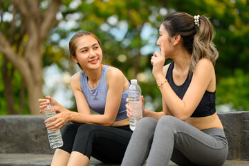 Female friends cooling down after exercise, enjoying conversation and hydration outdoors